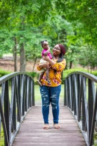 Terri and Aubrielle standing on a bridge in the park. 